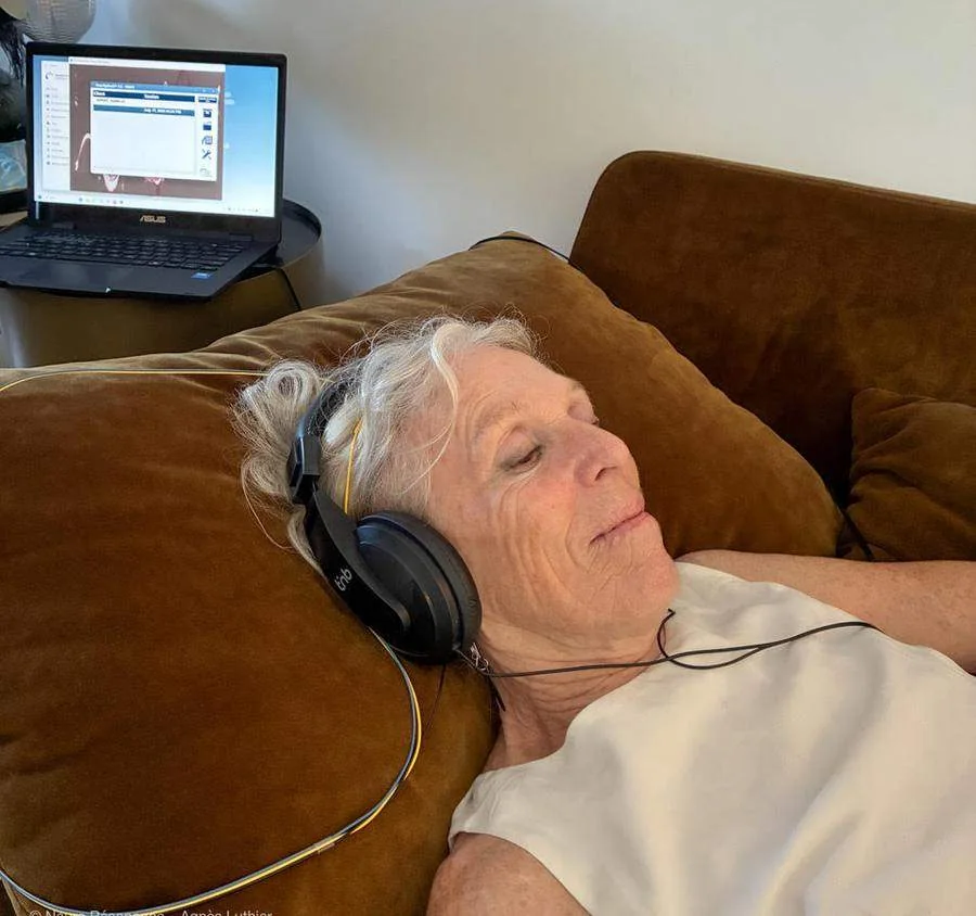 Femme allongée les yeux fermés, casque audio sur les oreilles, pendant une séance