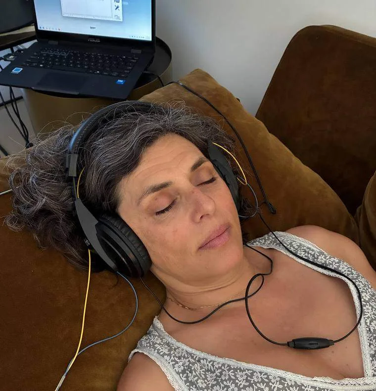 Femme allongée les yeux fermés, casque audio sur les oreilles