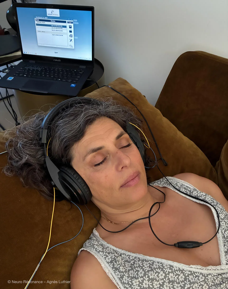 Femme allongée les yeux fermés, casque sur les oreilles, pendant sa séance
