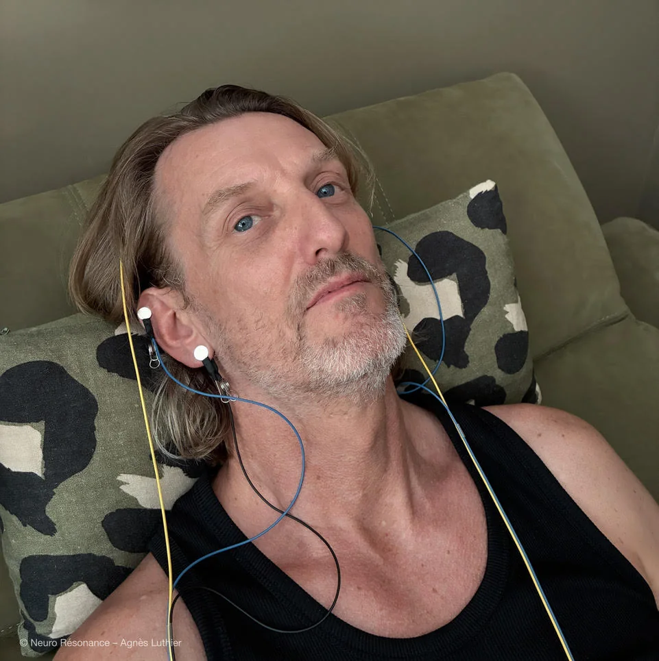 Homme allongé en séance, les capteurs posés sur les oreilles