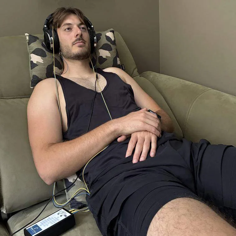 Jeune homme allongé sur un canapé, casque audio sur les oreilles, pendant une séance
